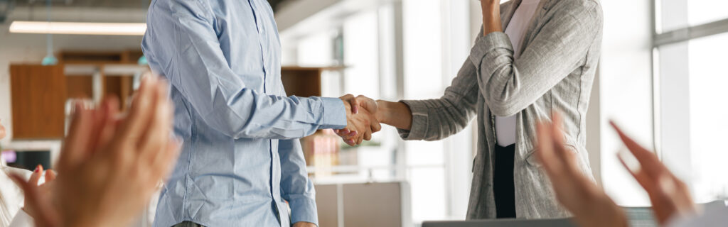 Close up of boss leader shaking hand of new team member recruiting him for job on staff briefin